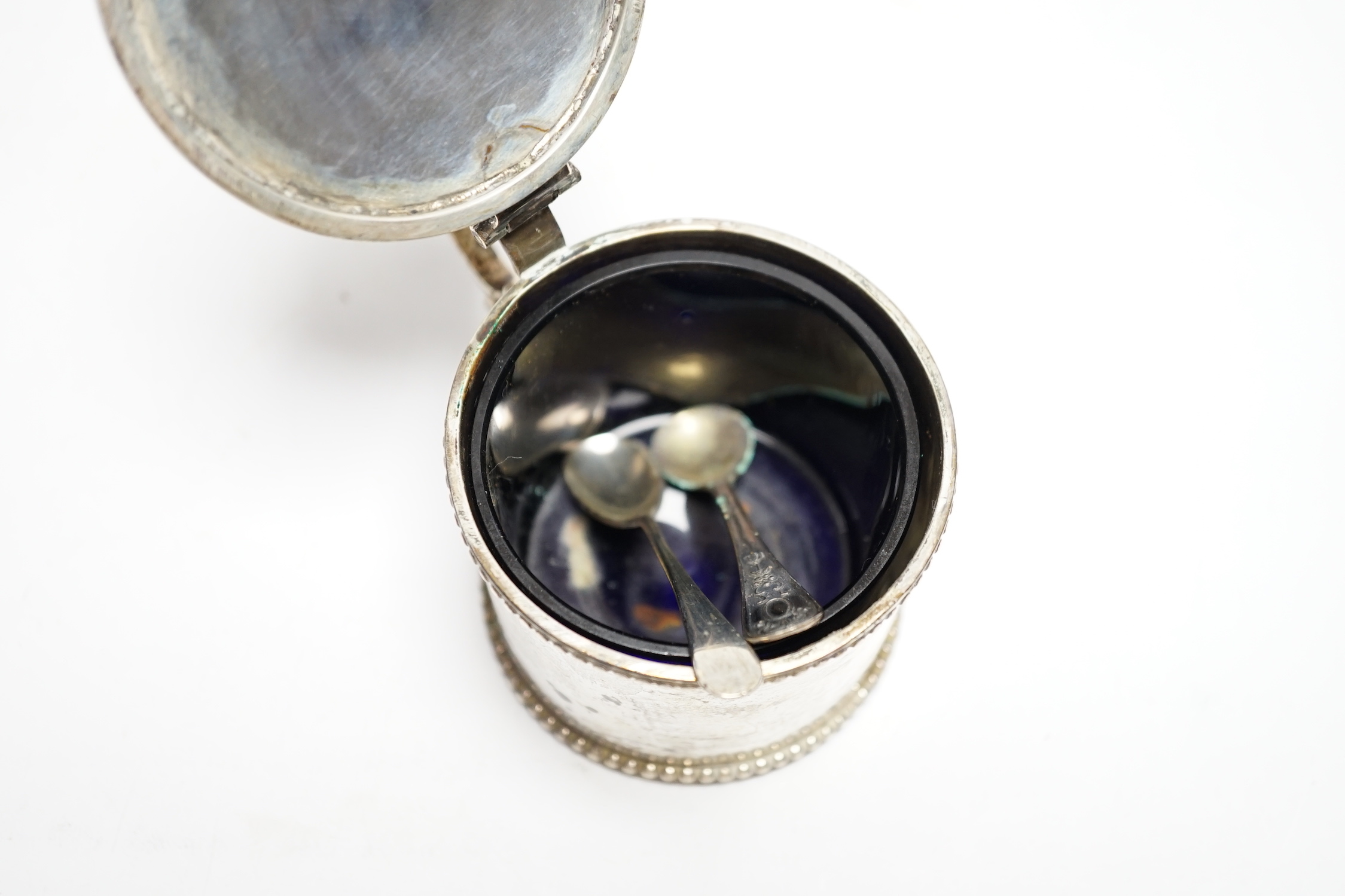 An early Victorian silver drum mustard, maker's mark rubbed, Birmingham, 1843, height 75mm, with two associated spoons, one silver.